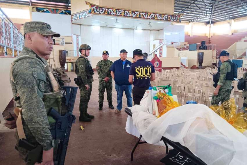 Lanao Del Sur Governor Mamintal Adiong Jr. stands among law enforcement officers as they investigate the scene of an explosion that occurred during a Catholic Mass in a gymnasium at Mindanao State University in Marawi, Philippines, Dec. 3, 2023.