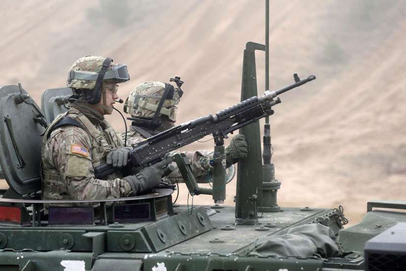 Soldiers of the U.S. Army&#039;s 2nd Cavalry Regiment, deployed in Latvia as part of NATO&#039;s Operation Atlantic Resolve, ride in an armoured vehicle during a joint military exercise in Adazi Feb. 26. Catholic officials in Latvia are trying to stay out of the region&#039;s ideological war with neighbouring Russia.
