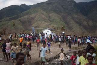 Victims of Hurricane Matthew walk towards an open area where an aid helicopter landed Oct. 10 in Tiborun, Haiti. As a sign of his closeness and concern, Pope Francis sent aid money to hurricane-stricken Haiti, to be distributed through the hardest-hit dioceses to assist flood victims. 