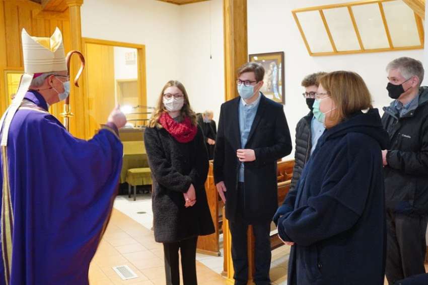 Archbishop Richard Smith of Edmonton, Alberta, meets with parishioners after a Dec. 20, 2020, Mass at Santa Maria Goretti Parish in Edmonton.