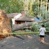 A child looks at a house in Falls Church, Va., June 30 that was struck by a tree after a violent thunderstorm ripped through the area late June 29. Wind gusts clocked at speeds of up to 79 mph were reported in and around the nation&#039;s capital, knocking out power to hundreds of thousands of homes.