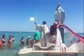Italian priest Father Mario Calogiuri came to beach of San Foca with a five-foot statue of the Virgin Mary on a paddle boat to bless the beachgoers.