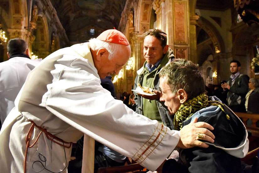 Cardinal Ricardo Ezzati of Santiago greets homeless guests and invites them into the cathedral Aug. 19.