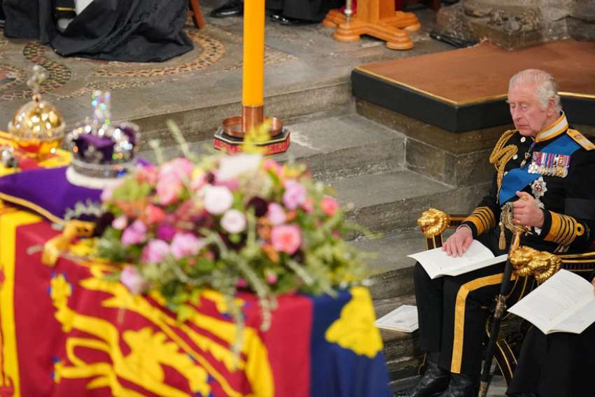 King Charles III sits in front of the coffin of his mother, Queen Elizabeth II, during her state funeral at Westminster Abbey in London Sept. 19, 2022.