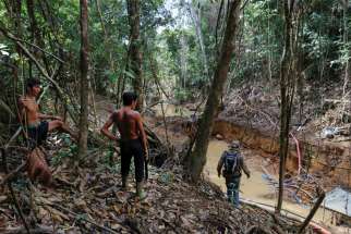 Yanomami Indians follow agents of Brazil’s environmental agency during an operation against illegal gold mining on Indigenous land in the heart of the Amazon rainforest.