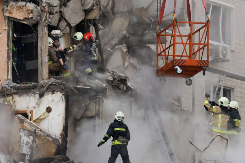 Emergency personnel evacuate a person Jan. 15 from a building in an apartment block that was heavily damaged by a Russian missile strike in Dnipro, Ukraine. Catholic aid agencies in Canada have been working to help settle more than 130,000 Ukrainian nationals that have come to Canada in the last year.