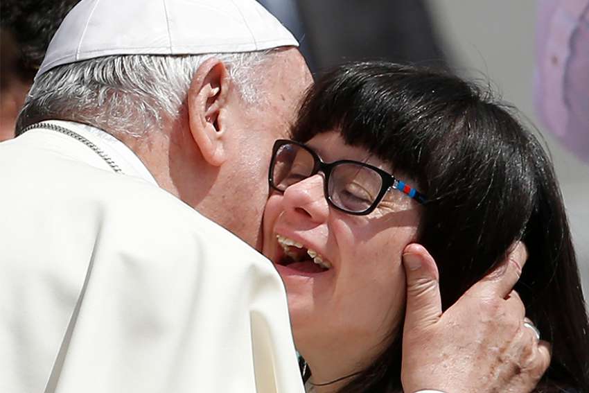 Pope Francis embraces a woman as he meets the disabled during his general audience in St. Peter&#039;s Square at the Vatican June 13. 