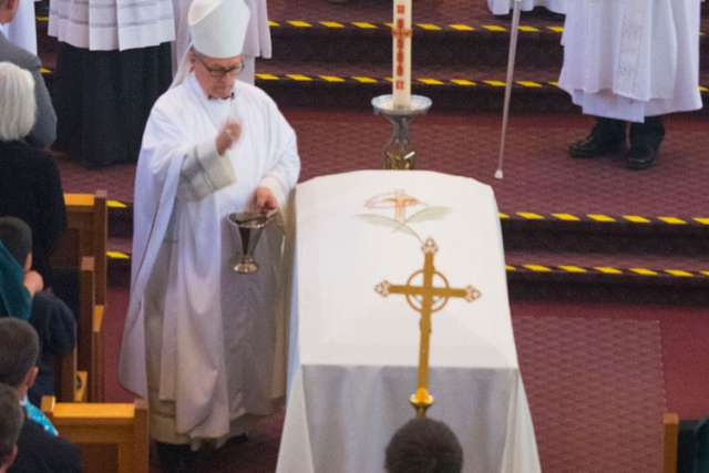 St. Paul Bishop Paul Terrio incenses the coffin of Fr. Gilbert Dasna at the slain priest&#039;s funeral May 19.