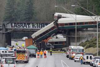 Rescue personnel and equipment are seen Dec. 19 after Amtrak train 501 derailed onto Interstate 5 in Dupont, Wash. At least three people were killed and dozens injured after the train derailed Dec. 18 while traveling on the first day of a new route outside Tacoma, careening off a bridge and onto a highway below. 