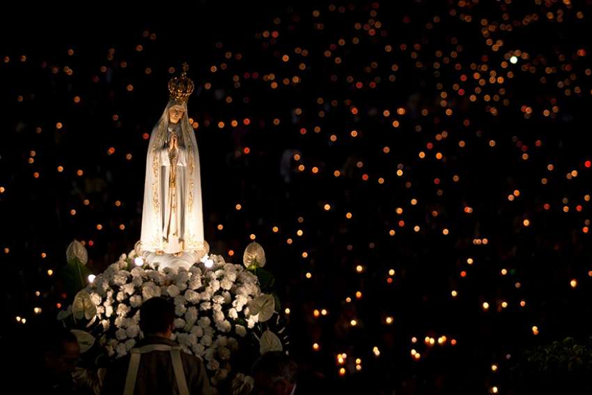 A statue of Mary is carried through the crowd in 2013 at the Marian shrine of Fatima in central Portugal. May 13 will mark the 100th anniversary of the first appearance of Our Lady of Fatima in Portugal.