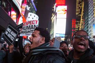 Protesters, demanding justice for the death of Eric Garner, hold placards while shouting slogans Dec. 3 in Times Square in the Manhattan borough of New York. Thousands of protesters shouted at police and clogged streets of Manhattan, angered by a New Yor k City grand jury&#039;s decision not to charge white Police Officer Daniel Pantaleo in the chokehold death of the unarmed Garner, who was black.