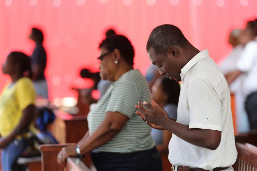  People pray during Mass in 2015 outside Sacred Heart Church in Port-au-Prince, Haiti. Five priests, two nuns and three laypeople were kidnapped in Haiti April 11, 2021.