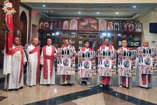 Coptic clergy hold signs to remember victims of the Palm Sunday attack in Egypt during a service at the Church of Virgin Mary and St. Athanasius on April 18, 2017, in Mississauga, Ontario.