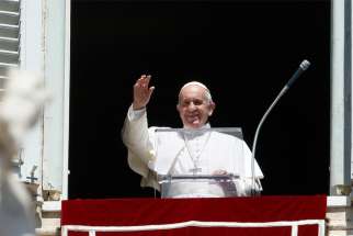 Pope Francis greets the crowd as he leads the Angelus from the window of his studio overlooking St. Peter&#039;s Square at the Vatican.