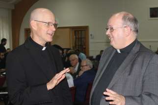 Msgr. Stephen Rossetti, left, speaks with Fr. Raymond Lafontaine during an Oct. 26 day-long conference for Montreal priests. 