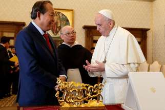  Pope Francis exchanges gifts with Truong How Binh, vice prime minister of Vietnam, during a private audience at the Vatican Oct. 20.