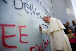 Pope Francis prays in front of the Israeli security wall in Bethlehem, West Bank, during his 2014 visit. 