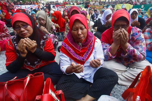 Muslim women pray outside the court in Putrajaya, Malaysia, June 23. Malaysia&#039;s highest court rejected a Catholic Church challenge to a Court of Appeal decision to prohibit the weekly Herald Bahasa Malaysia section from using the word &quot;Allah.&quot;