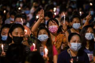 People hold candles as they take part in an anti-coup protest in Yangon, Myanmar, March 14, 2021.