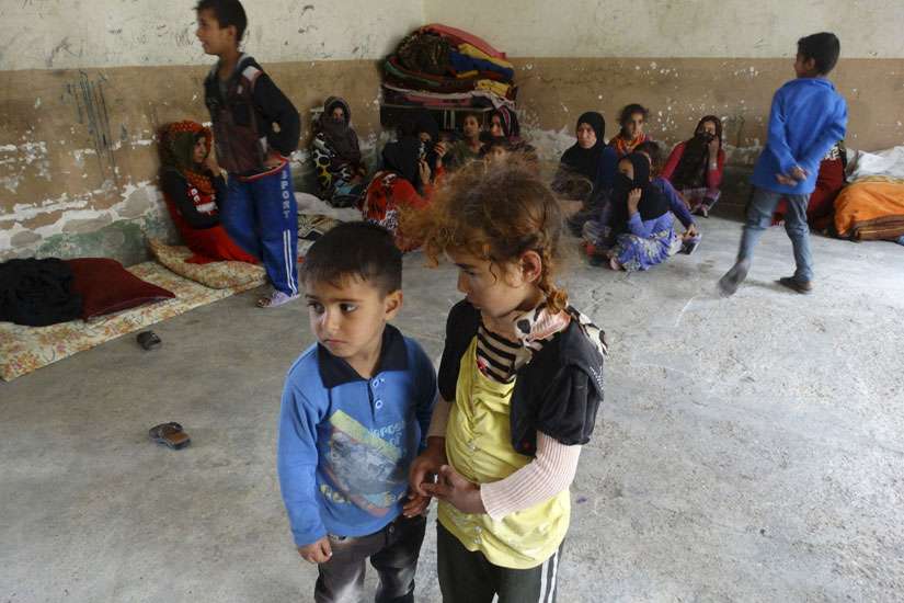 Displaced Iraqi children stand in a classroom of a school used as a shelter in the city of Ramadi April 11. Educating children is the best way to help displaced Iraqi Christians recover from the traumatic experience of being chased from their homes by Is lamic State militants, said Cardinal Vincent Nichols of Westminster after an April 11-12 visit to Irbil.