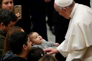 Pope Francis greets a baby during his general audience in Paul VI hall at the Vatican Jan. 9.