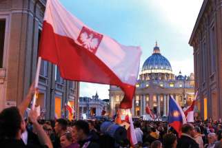Poland’s flag is seen as pilgrims wait on Via della Conciliazione outside St. Peter’s Square at the Vatican April 26, the eve of the canonization of Sts. John XXIII and John Paul II.