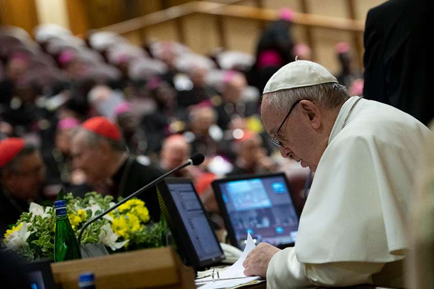 Pope Francis reviews papers during the third-day of a meeting on the protection of minors in the church at the Vatican Feb. 23, 2019. 