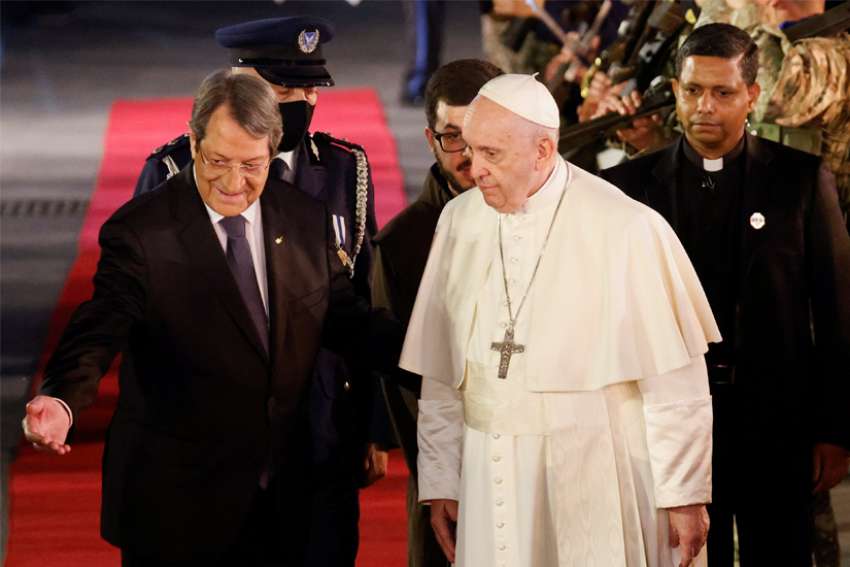 Pope Francis walks with Cypriot President Nicos Anastasiades as he arrives for a welcoming ceremony at the presidential palace in Nicosia, Cyprus, Dec. 2, 2021.
