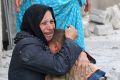 A woman cries as she holds a boy at a site hit by what activists said was a barrel bomb dropped by forces loyal to Syrian President Bashar Assad in Aleppo, Syria. Wael Suleiman, executive director of Caritas Jordan said the influx of Syrian Christian refugees into Jordan is on the rise. 