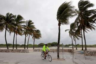 A man rides his bicycle along the beach Oct. 6 prior to the arrival of Hurricane Matthew in Miami Beach.