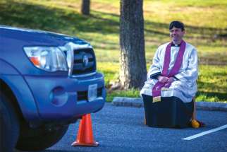 Fr. Scott Holmer, a pastor in Bowie, Md., offers drive-through confessions in the parking lot of his parish church, keeping a safe distance away from penitents amid the coronavirus pandemic.