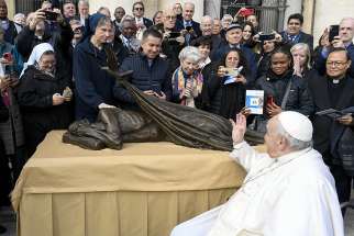 Pope Francis waves to members of the Vincentian religious orders and lay communities Nov. 9, 2022, after blessing Canadian artist Timothy Schmalz&#039; new sculpture, Sheltering. The statue, which features a dove laying a blanket over a homeless person, will be used in conjunction with a Vincentian project to build homes for some 10,000 people in 160 countries.