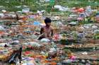 In this Sept. 9, 2014, file photo, a young man collects items on Jawahar Lal Nehru Lake after a festival in Bhopal, India. Some doctors say patients have a right to have causes of illness, especially from environmental pollution, studied as part of their care.