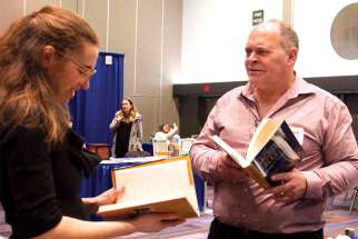 Peter Elliott browses books with fellow Catholic author Anna Eastland at the Catholic Educators’ Conference last month.