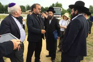 Fr. Patrick Desbois, second from left, greets visitors at the Rava-Ruska Holocaust mass grave on June 29, 2015. Desbois found and documented more than 1,600 Jewish mass graves in Ukraine and elsewhere in Eastern Europe.