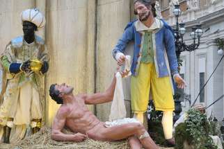 Life-size statues depict the corporal work of mercy of clothing the naked in the Nativity scene in St. Peter&#039;s Square at the Vatican Dec. 14.