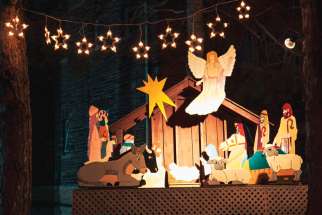 Volunteers at St. Brigid’s Parish in Toronto started their Advent journey by assembling the Nativity scene in front of the church. Below, one of the construction crew carefully places the Virgin Mary in front of the Christ child.