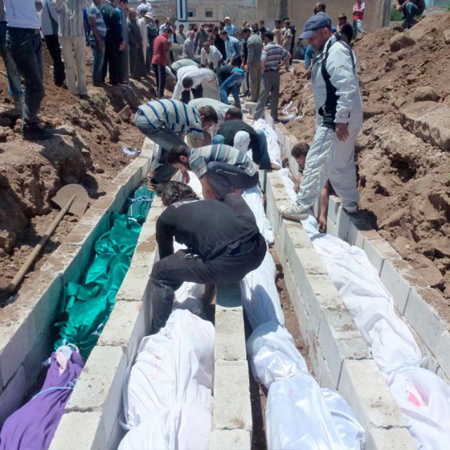 People gather at a mass burial for the victims killed during an artillery barrage from Syrian forces in Houla, Syria, in this handout image dated May 26. Pope Benedict XVI joined the international community in condemning a massacre in Houla, Syria, May 2 5-26, which left about 108 people dead, including 49 children and 34 women. 