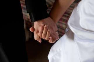 A groom and bride hold hands on their wedding day.