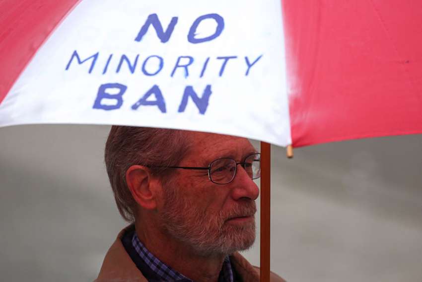 A man holds an umbrella during a protest in Seattle May 15 against President Donald Trump&#039;s travel ban. The U.S. Court of Appeals for the 4th Circuit, based in Virginia, issued a 10-3 ruling May 25 to uphold a Maryland federal court&#039;s injunction against the temporary ban.