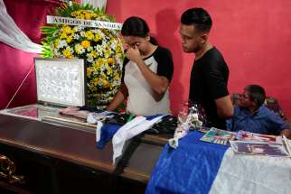Young people mourn over the casket of Gerald Jose Vasquez, a student at the National Autonomous University of Nicaragua, during his July 15 wake in Managua. Vasquez was one of two students shot and killed by paramilitary forces when they were seeking refuge in Divine Mercy Catholic Church after being forced from the university they had occupied in protest for more than two months. 