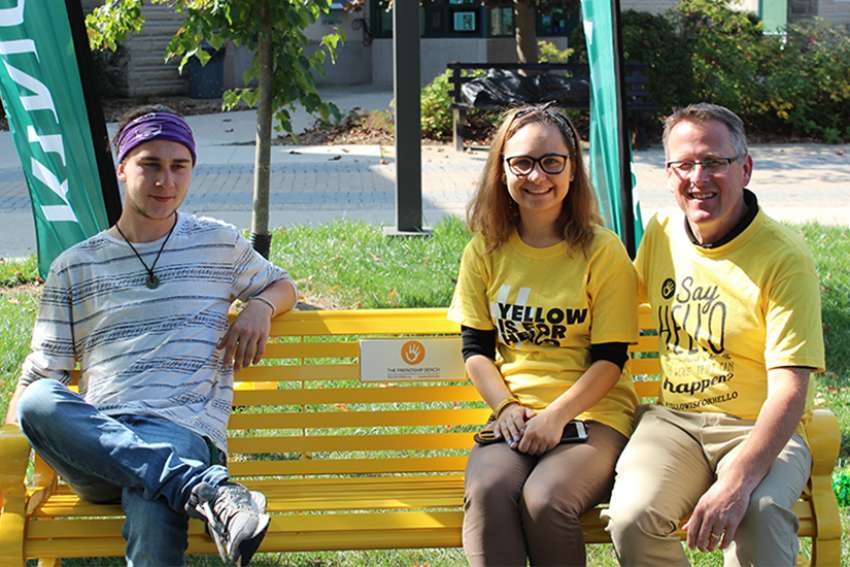 Violette Khammad, president of King&#039;s student council, and Dean of Students Joe Henry sit on the school&#039;s Friendship Bench. The Friendship Bench program started in 2014 and benches have been installed in 35 locations across Canada. 