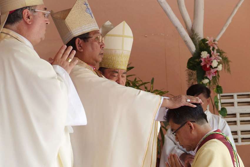 Cardinal-designate Louis-Marie Ling Mangkhanekhoun, apostolic vicar of Pakse, Laos, places his hands on a new bishop during a 2010 ordination Mass. Cardinal-designate Ling is one of five new cardinals Pope Francis will create at a June 28 consistory.