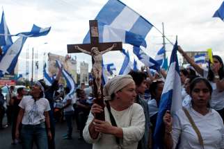 A demonstrator holds a crucifix during a protest against Nicaraguan President Daniel Ortega&#039;s government in Managua, Nicaragua, May 15.