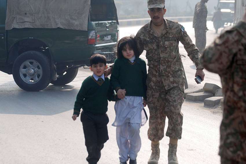 A soldier escorts schoolchildren from the Army Public School in Peshawar, Pakistan, Dec. 16, 2014. Archbishop Sebastian Shaw of Lahore says the increased security around Catholics schools are, psychologically, making children feel unsafe.