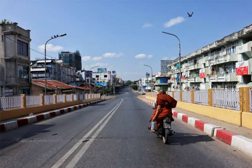 People ride a motorbike down an almost empty street as locals stage a &quot;silent strike&quot; in Mandalay, Myanmar, Dec. 10, 2021. People from all walks of life in Myanmar observed another &quot;silent strike&quot; in defiance of the ruling junta Feb. 1, 2022, the anniversary of the military coup.