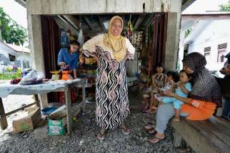 Nyak Minah stands in front of a store she added to the front of her home in Kubang Gajah, Indonesia, Nov. 4. Ten years after a giant tsunami swept across South Asia, survivors across the region still wrestle with the trauma that lingers long after the wa ter receded from thousands of seaside towns and villages.