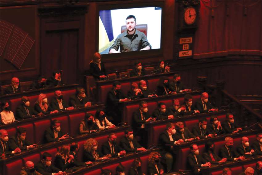 Ukrainian President Volodymyr Zelenskyy appears on a large  screen as he addresses the Italian Parliament. Zelenskyy received a standing ovation from Italian politicians at the end of his address via video link in Rome March 22 during Russia’s invasion of Ukraine. Zelenskyy spoke on the phone with Pope Francis before addressing the parliament, thanking the Pope “for the prayers for Ukraine and peace.”