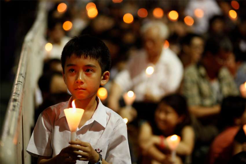 A boy takes part in a candlelight vigil at Victoria Park in Hong Kong June 4, 2013, to mark the anniversary of the crackdown on the pro-democracy movement in Beijing&#039;s Tiananmen Square in 1989. This year&#039;s vigil has been canceled by Hong Kong police, but seven Catholic churches scheduled Masses for June 4, 2021, at the time the vigils would normally occur.