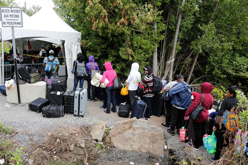 A group of Haitians wait to cross the U.S.-Canada border into Quebec from New York in late August. 